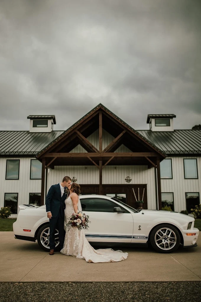 Newlyweds outside the covered timber entrance at Rustic Ridge Wedding Barn