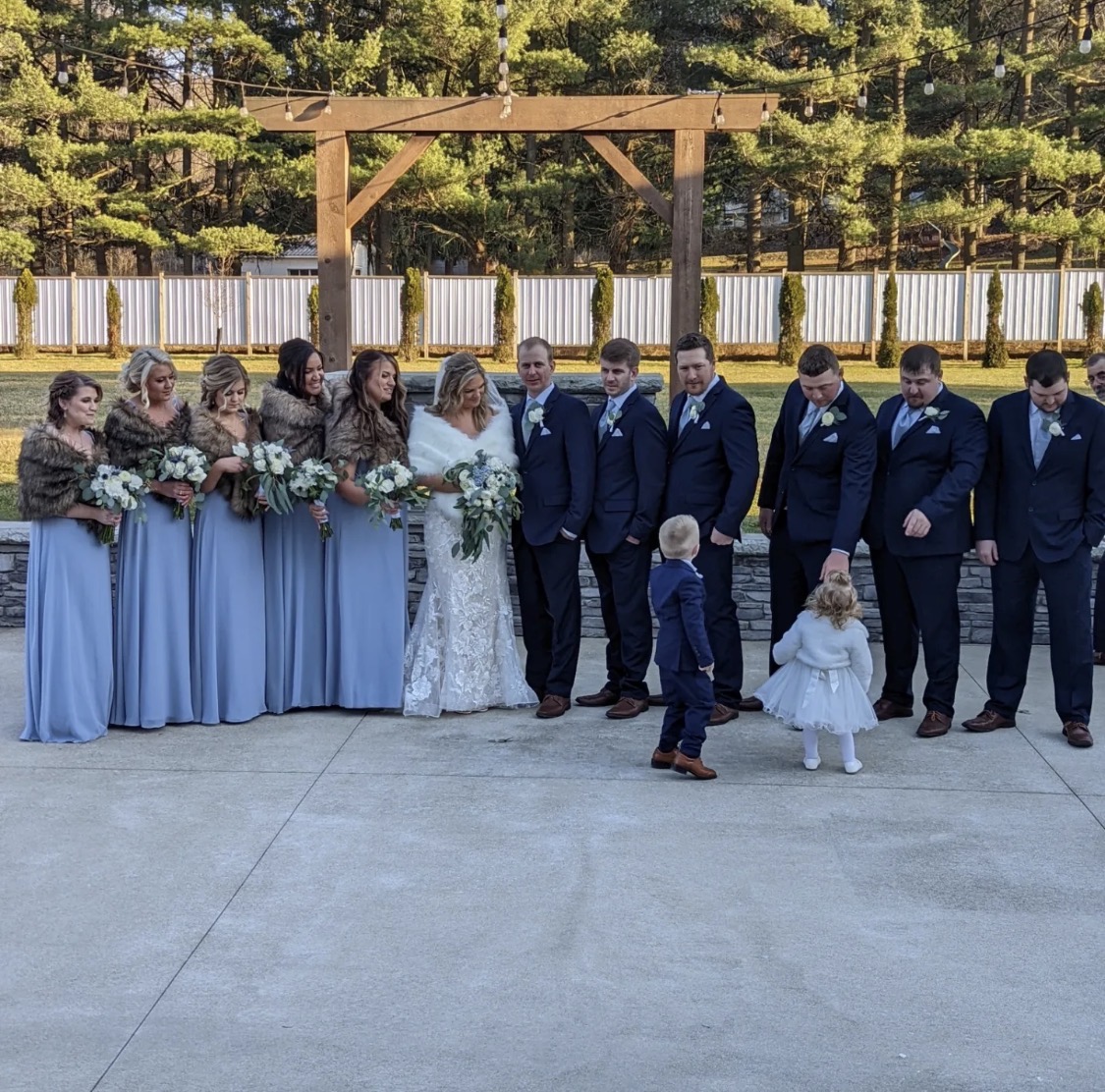 Winter bridal party Winter bridal party in dusty blue and navy standing at the pergola and stone wall